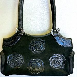 Women’s suede purse with leather flower design.